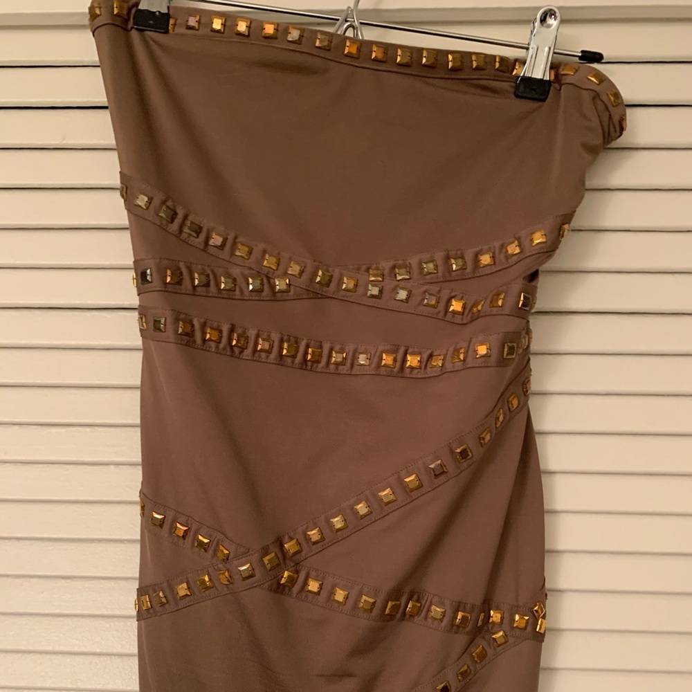 Mini dress strapless with metallic applications.